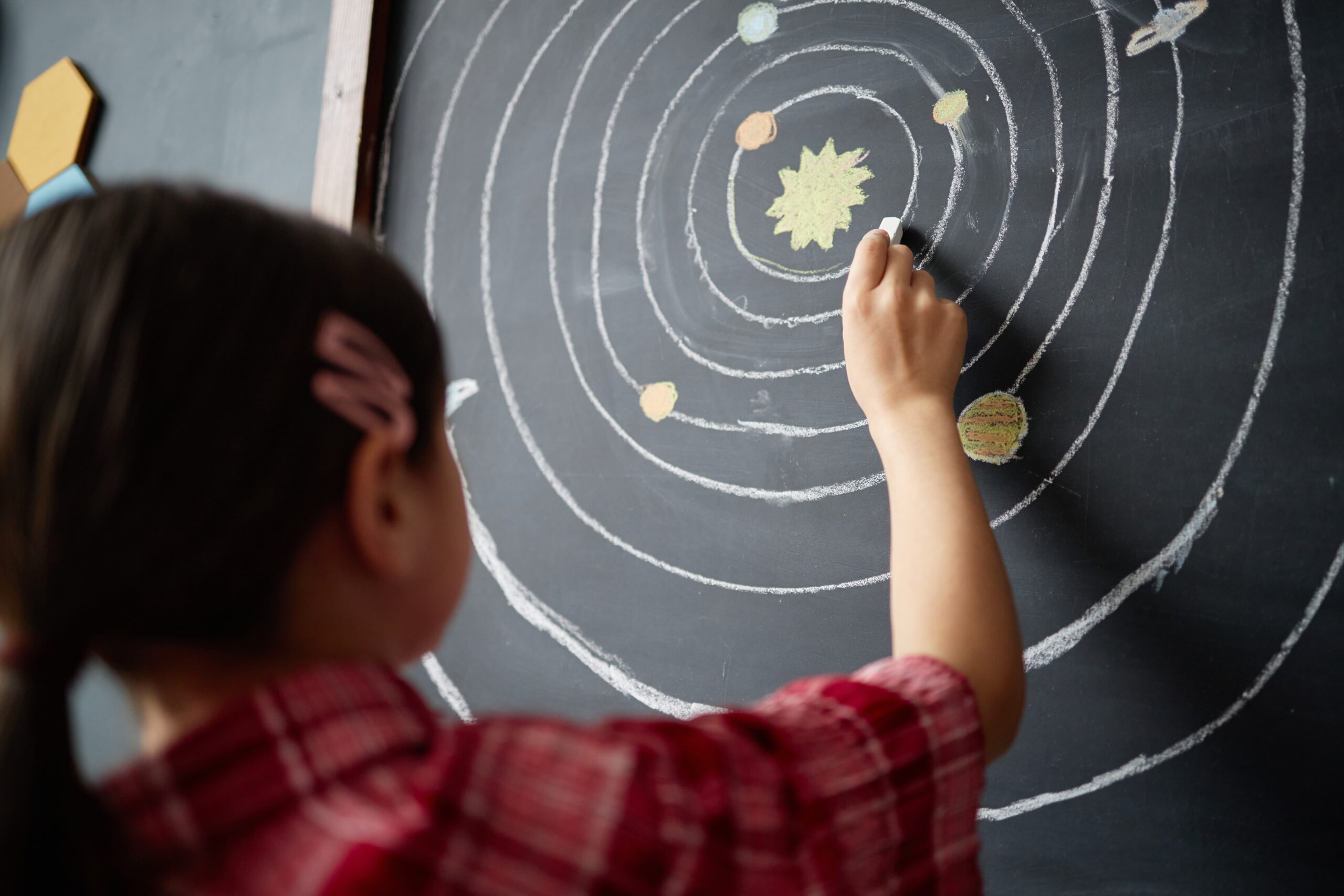 Girl,Child,Drawing,Solar,System,Diagram,On,Chalkboard,,Reaching